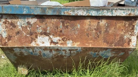 An old rusty container stands motionless in a field overgrown with tall grass Stock Footage 316387334