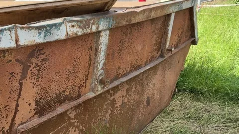 An old rusty container stands motionless in a field overgrown with tall grass Stock Footage 316387413