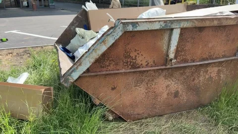 An old rusty container stands motionless in a field overgrown with tall grass Vidéo 316387750