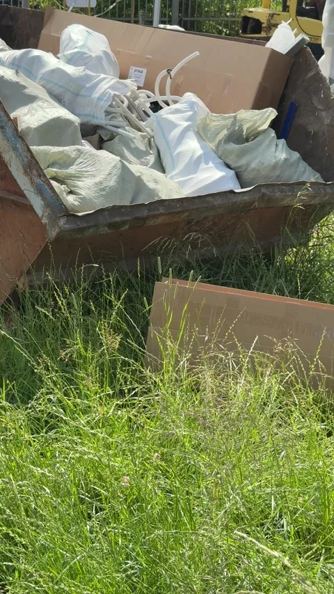 An old rusty container stands motionless in a field overgrown with tall grass Stock Footage 316388243