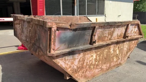 An old rusty container stands motionless in a field overgrown with tall grass Stock Footage 316388391