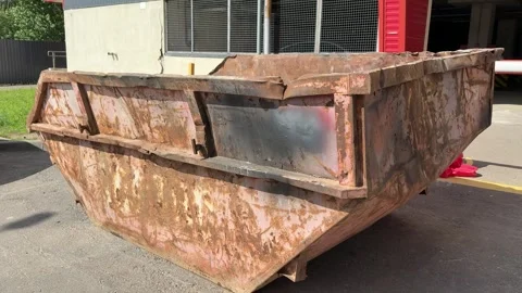 An old rusty container stands motionless in a field overgrown with tall grass Vidéo 316388686