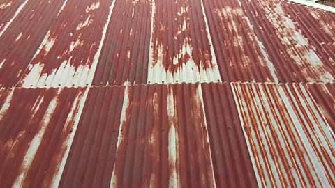 Old rusty corrugated tin shed roof with weathered and peeling paint textures Vídeo Stock 343553795