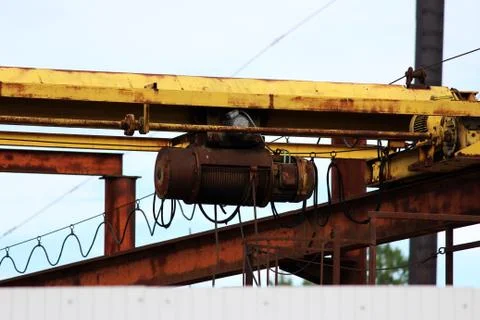Old rusty crane beam in the warehouse under the open sky near the building su Foto stock gratuite