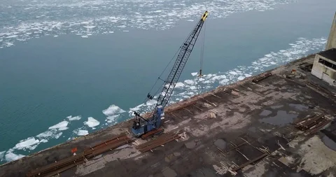 An old rusty crane sits abandoned along the Detroit River in winter. Stock Footage 102580046