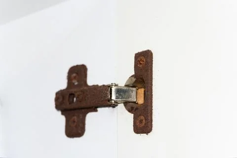Old rusty door hinge, cabinet hinges, outdated bathroom hinge covered in rust Stock Photos