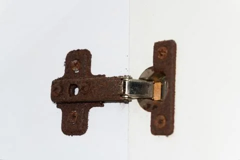 Old rusty door hinge, cabinet hinges, outdated bathroom hinge covered in rust Stock Photos