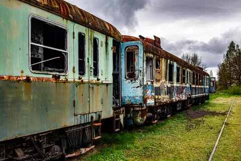 Old rusty electric multiple units abandoned on unused railway tracks Stock Photos