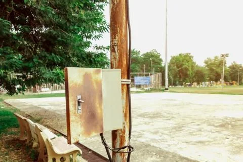 Old rusty electrical power control box on rusted electric pole in the public  Stock Photos