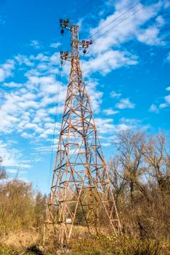 Old rusty electricity pylon under blue sky Stock Photos