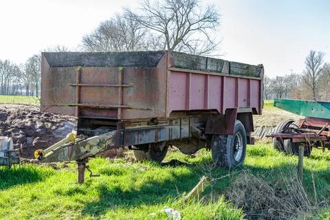 Old, rusty, empty farm trailer to be pulled by tractors Stock Photos