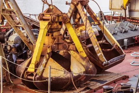 Old rusty excavator bucket lying on the deck of a river ship Stock Photos