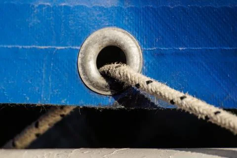 Old rusty eyelets on an aged blue coated plastic canvas Stock Photos