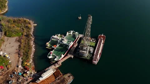 Old rusty ferry boats and crane docked at beautiful Kotor Bay in Montenegro Stock Footage 313733202
