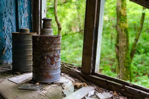 Old rusty filter boxes of gas masks on windowsill in abandoned primary school 스톡 사진