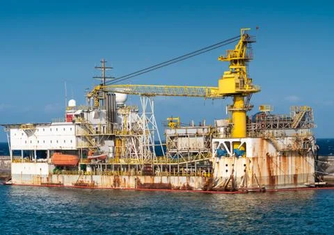 Old rusty floating docks in ocean port with heavy crane Stock Photos