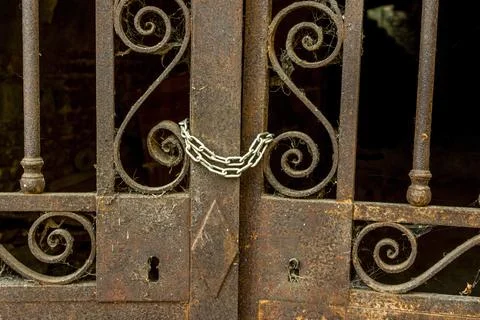 Old rusty gate locked by a chain Stock Photos