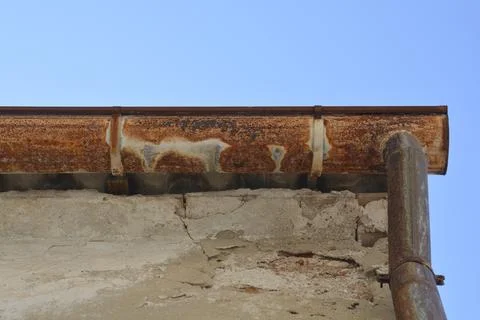 Old Rusty Gutter on Weathered Building Roof Stock Photos