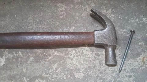 Old rusty hammer lying on concrete floor. Vintage hand tool for construction, Stock Photos