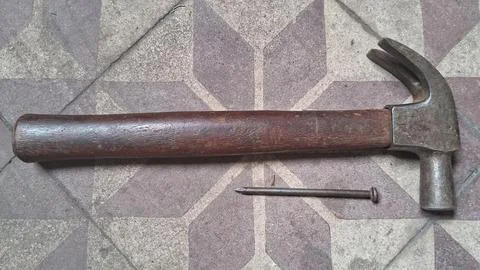 Old rusty hammer on weathered stone surface. Vintage hand tool for construction, Stock Photos
