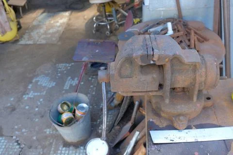Old rusty hand tools and vintage bench vise in a workshop. Foto stock