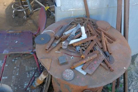 Old rusty hand tools and vintage bench vise in a workshop. Stock Photos