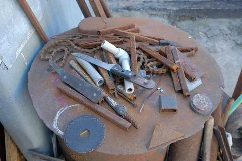 Old rusty hand tools and vintage bench vise in a workshop. Stock Photos
