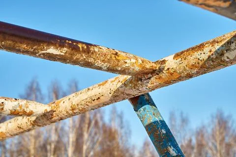 Old rusty horizontal bar. Old rusty climbing frames in the street against the Stock Photos