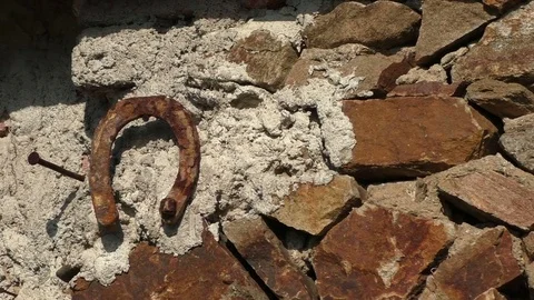 Old rusty horseshoe hanging on the stone wall Stock Footage 76571346