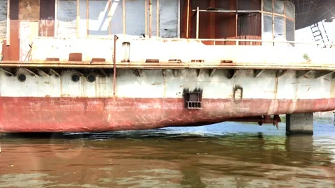 An old rusty inactive ship stands on the dock and the reflection of water Stock Footage 129507561