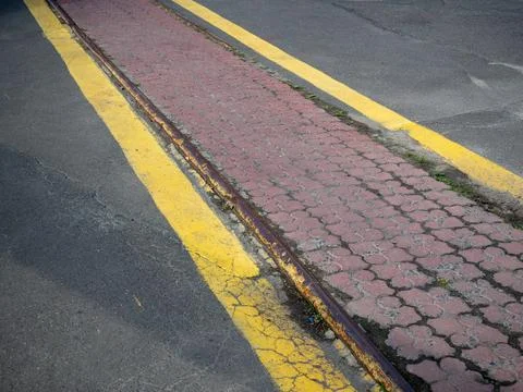 Old rusty industrial railway track embedded in asphalt road Stock Photos