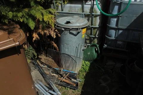 Old rusty iron and old bins with two water tanks in background Stock Photos