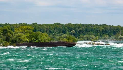 Old rusty iron barge stuck on rocks in a lake near Niagara Falls, Niagara S.. Foto stock