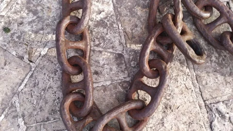 Old rusty iron chain laying on the stone floor. Close up of vintage metal heavy Stock Footage 233197782