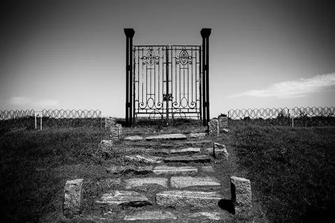 Old rusty iron gate in the middle of a field leading to nowhere. Concept of Stock Photos