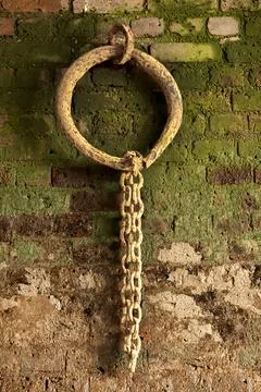 Old rusty iron mooring ring on a dockside wall Stock Photos
