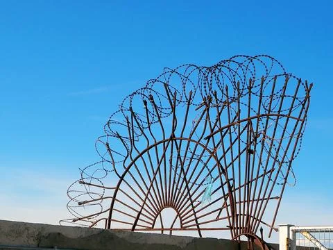 Old, rusty iron obstacle with barbed wire and prongs protecting a restricted Stock Photos