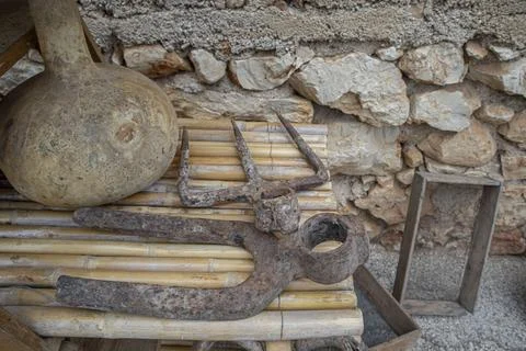Old rusty iron pitchfork heads and hand tools with a dried bottle gourd cal.. Stock Photos