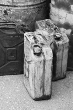 Old rusty jerrycans close-up, vertical black and white Stock Photos