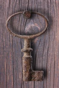 Old rusty key hanging on the wall, metal, rust, nail. Stock Photos