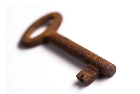 Old rusty key isolated on white background with shallow depth of field Foto stock