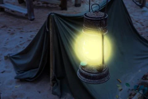 Old rusty Lighted lantern shining bright light during night, Miner camp, Surv Stock Photos