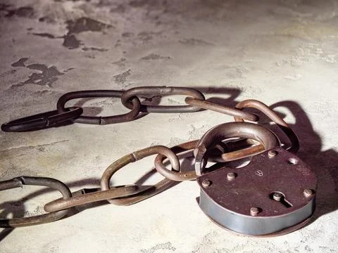 Old rusty link chain and padlock on concrete background, metal texture Stock Photos