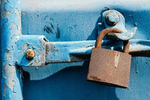 Old rusty lock on a blue background hanging on a sea shipping container Stock Photos