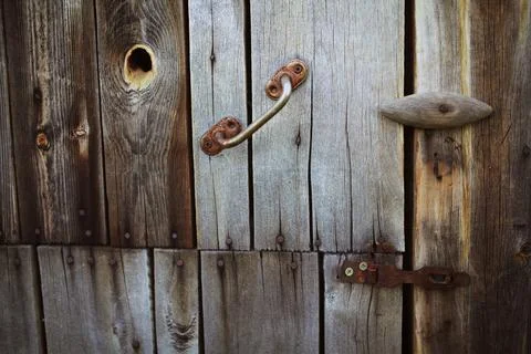 Old rusty lock hanging on the gray wooden door. Stock Photos
