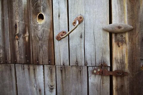 Old rusty lock hanging on the gray wooden door. Stock Photos
