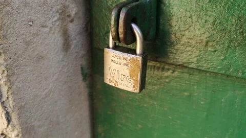 Old rusty metal lock on green door made from wood Stock Footage 232608791