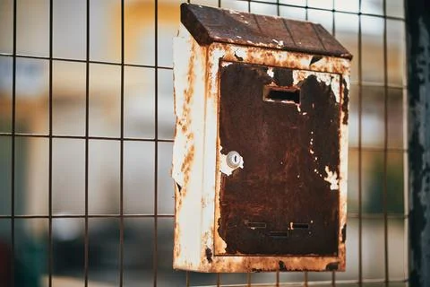 Old rusty metal mailbox mounted on a wire fence in Greece Stock Photos