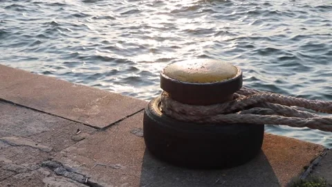 Old rusty metal pier or dock post, boat or ship tying berth, with ropes at ca Stock Footage 137728079