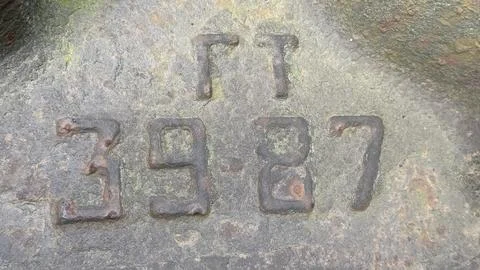 Old rusty metal surface with embossed numbers and letters Fotos de archivo